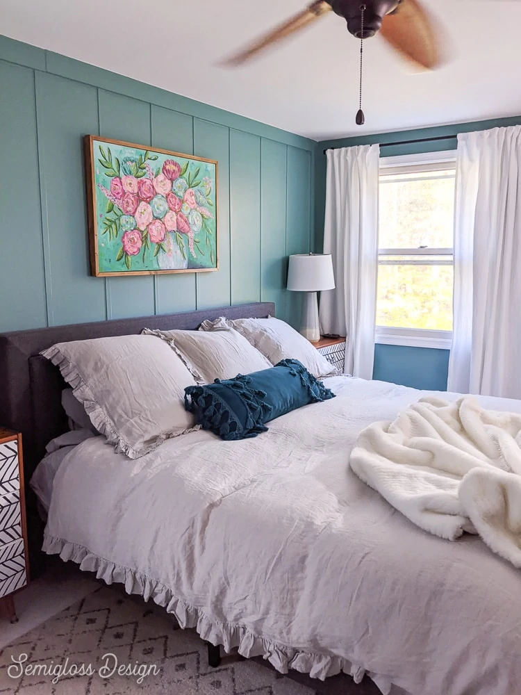 cozy master bedroom with fluffy gray bedding and teal walls