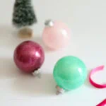 glitter ornaments with bottle brush tree in background