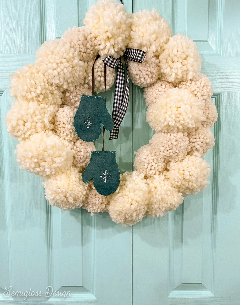 white fluffy yarn ball wreath on aqua door