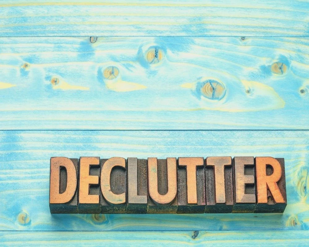 aqua wood background with stamp blocks that say declutter