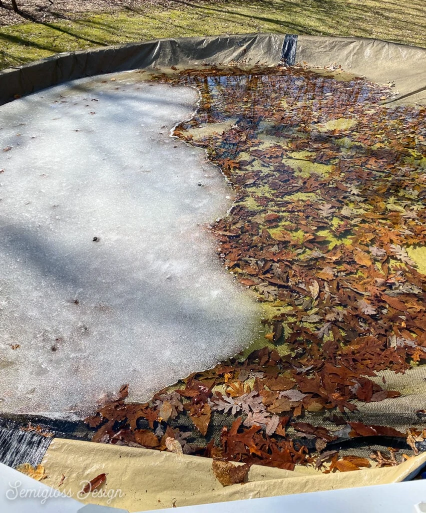 pool with cover filled with leaves and ice