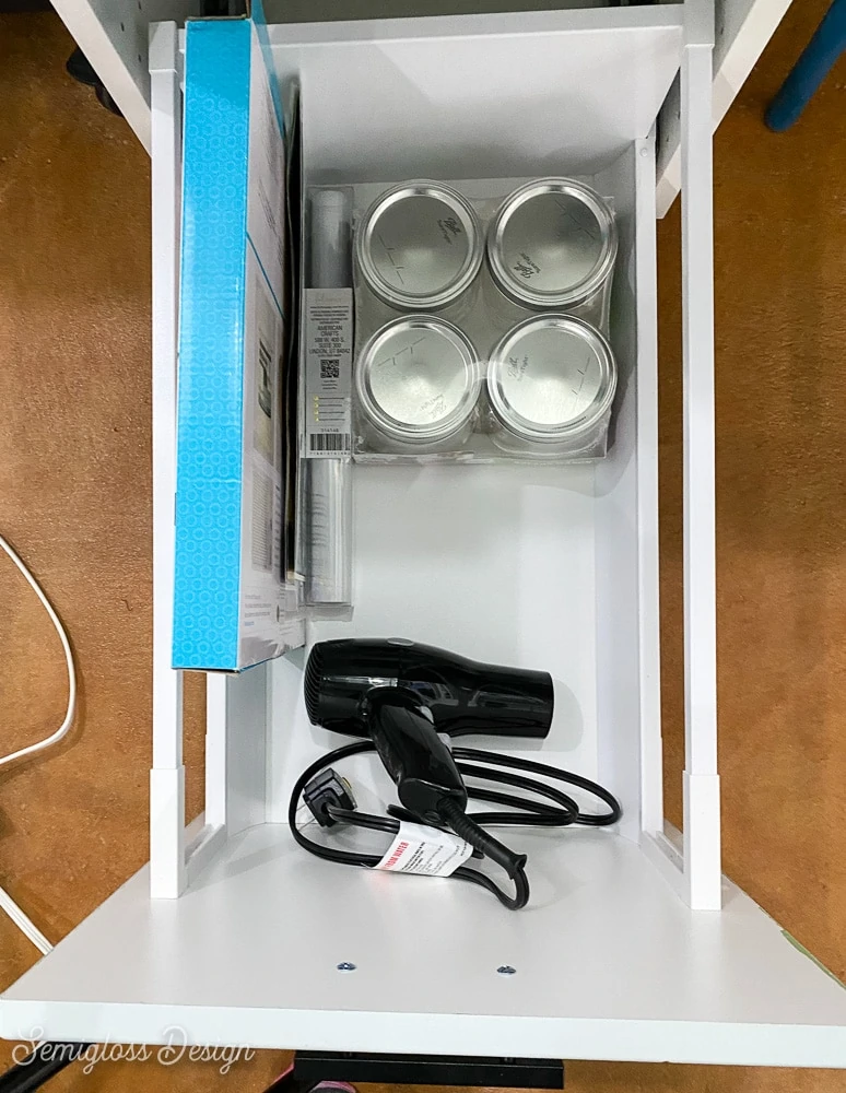 drawer with jars and a hair dryer