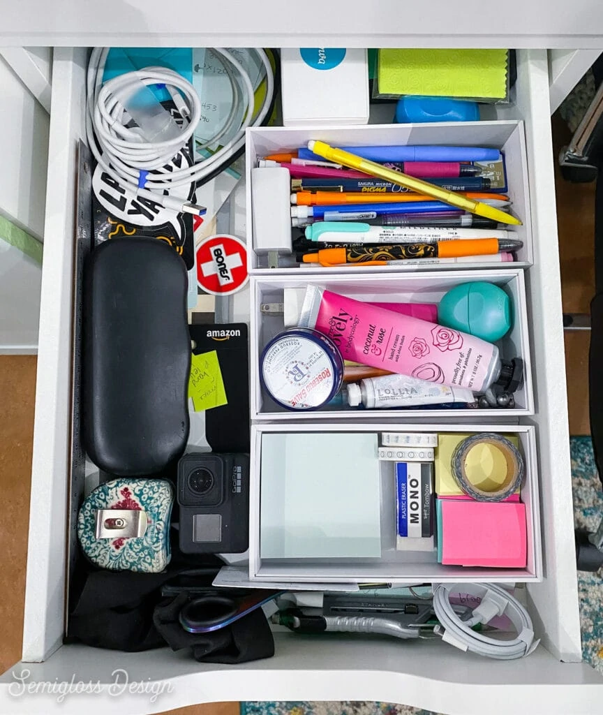 desk drawer with pens and post-it notes