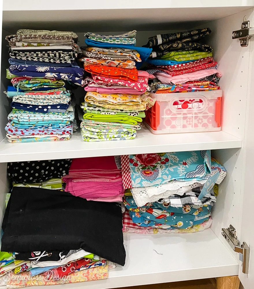 stacks of quilting fabric in cabinet