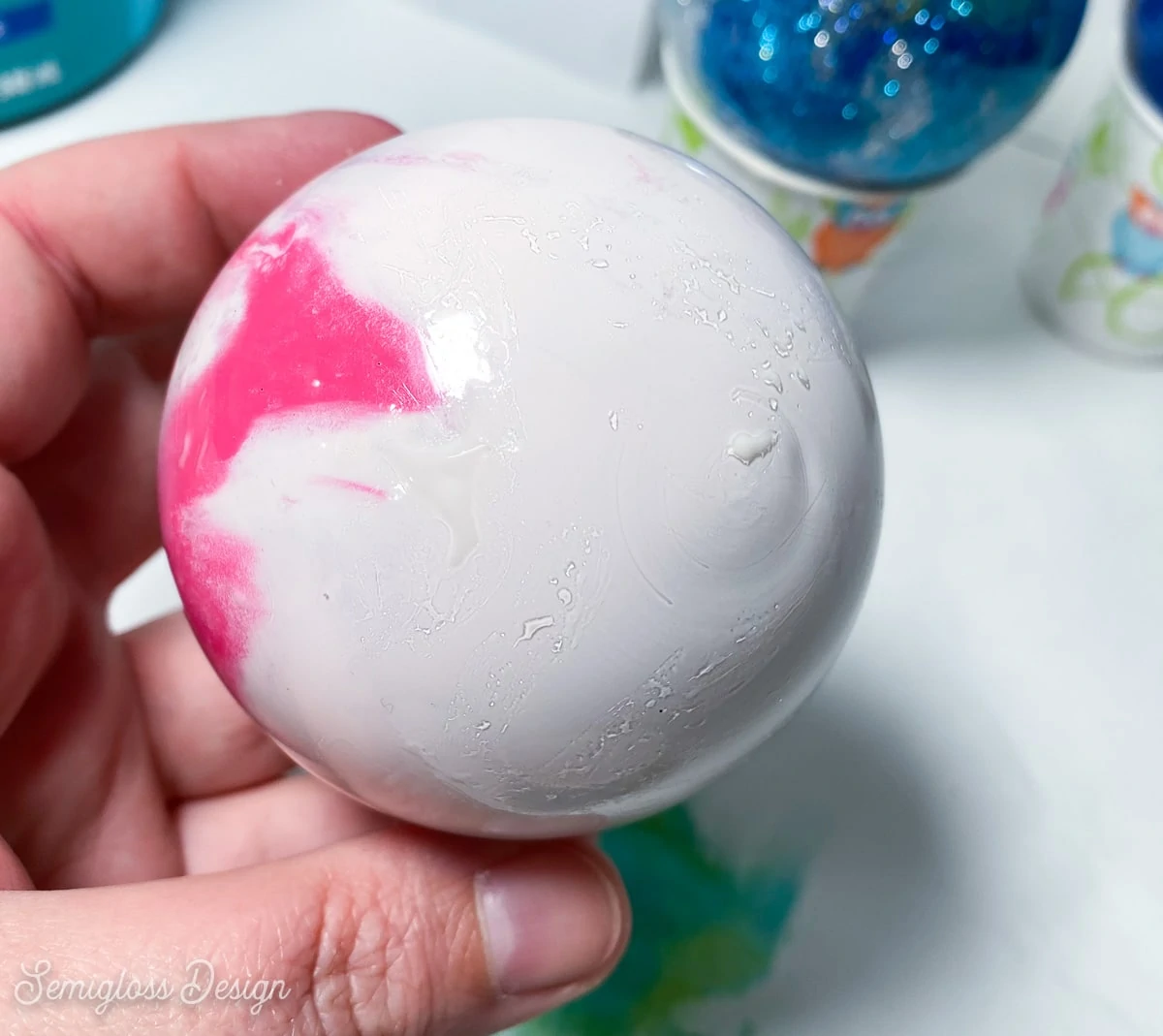 applying glue to pink swirl ornament