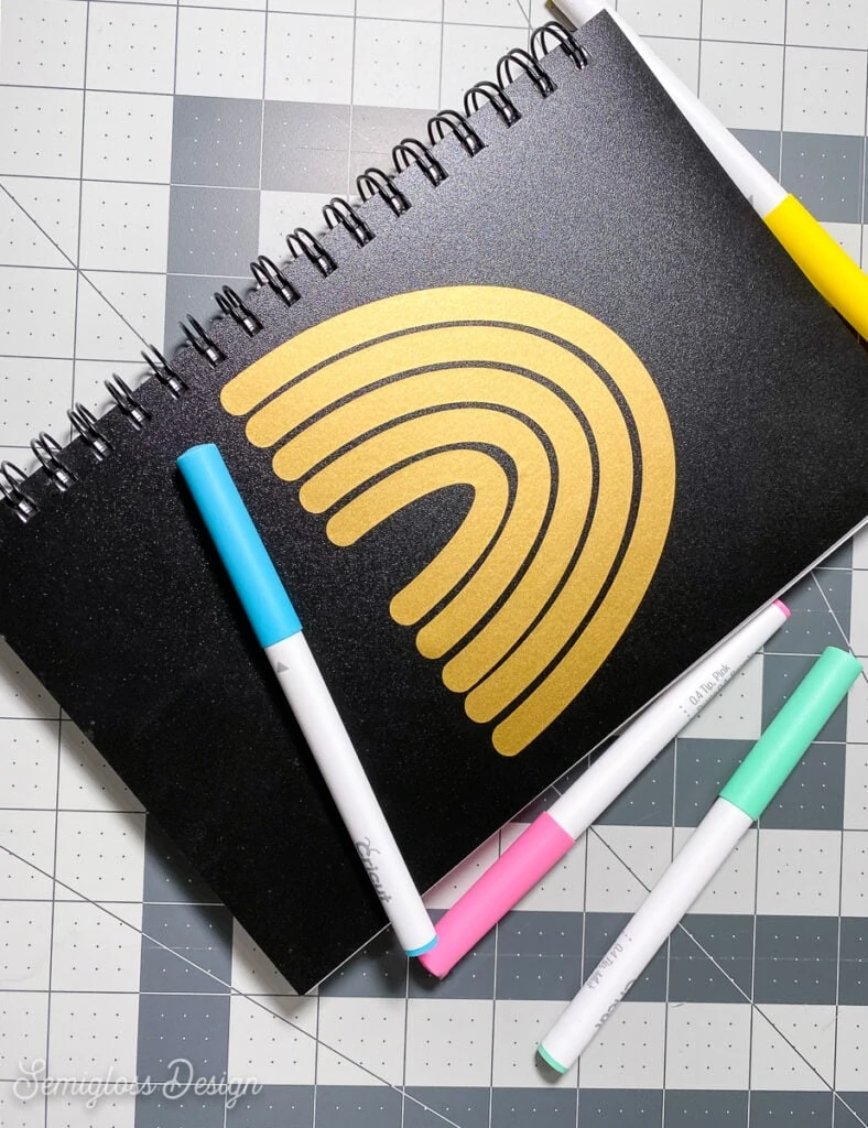 sketchbook with gold decal and pens