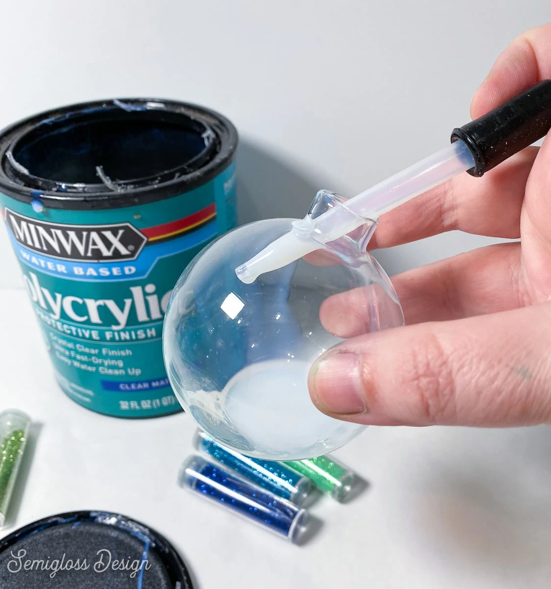 using an eyedropper to put polycrylic into glass ornament