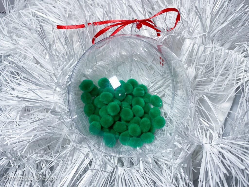 ornament filled with green pom poms