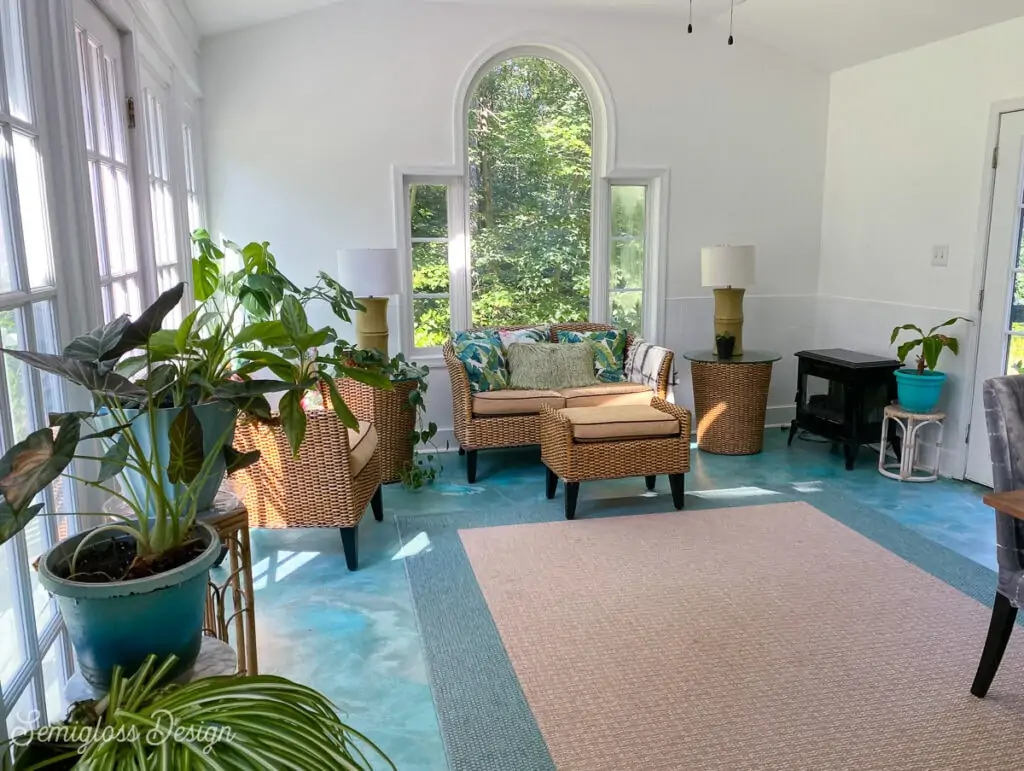 sunroom with teal floor and wicker furniture