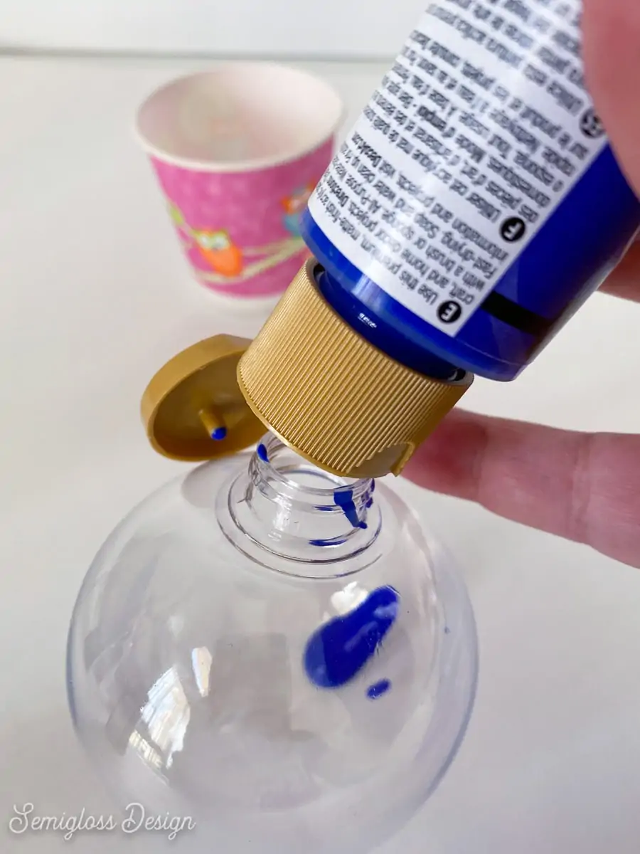 pouring blue paint into clear ornament