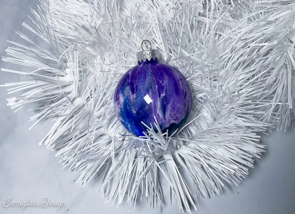 purple paint swirl galaxy ornament on white tinsel