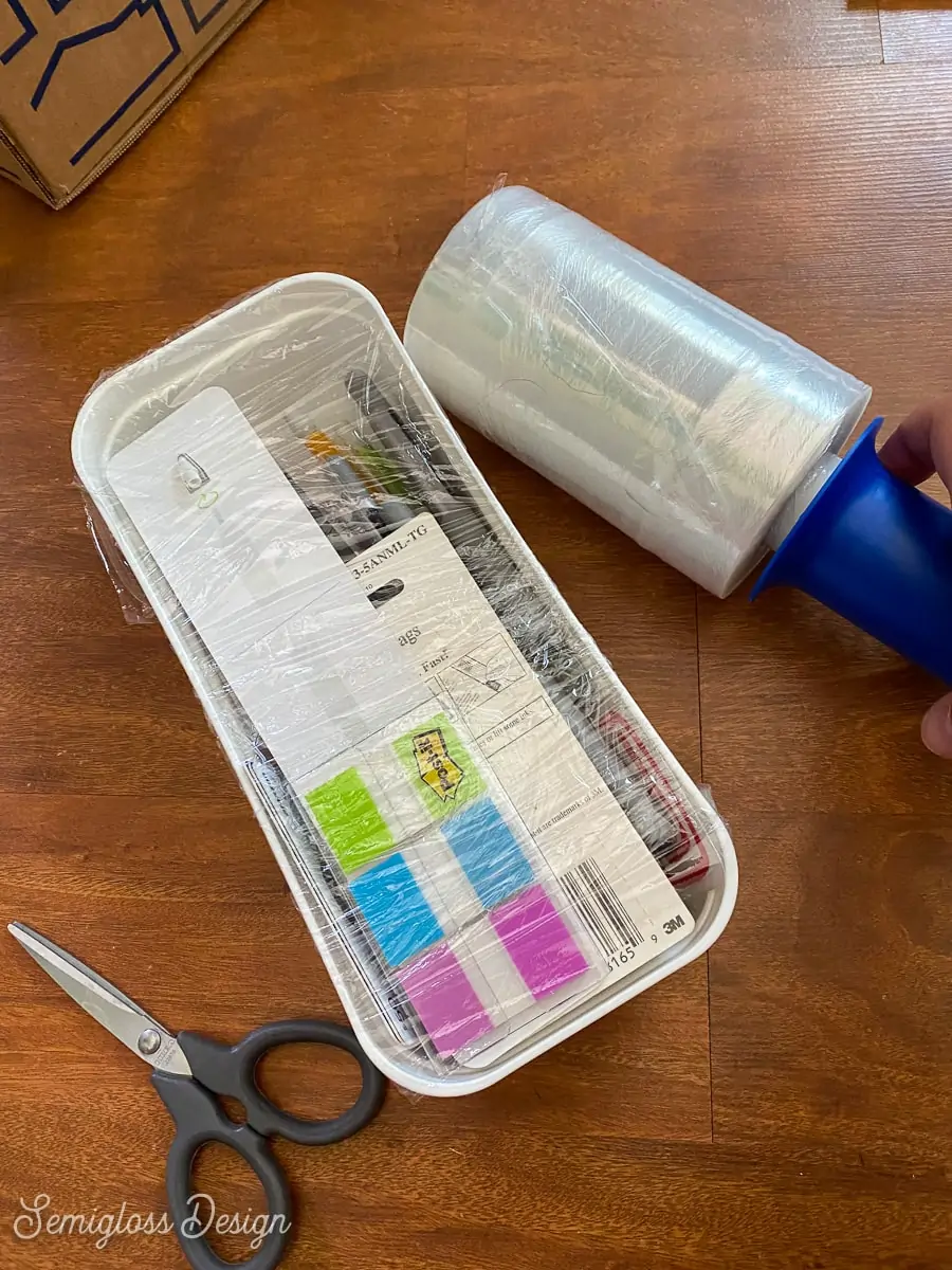 stretch wrap on a container of pens