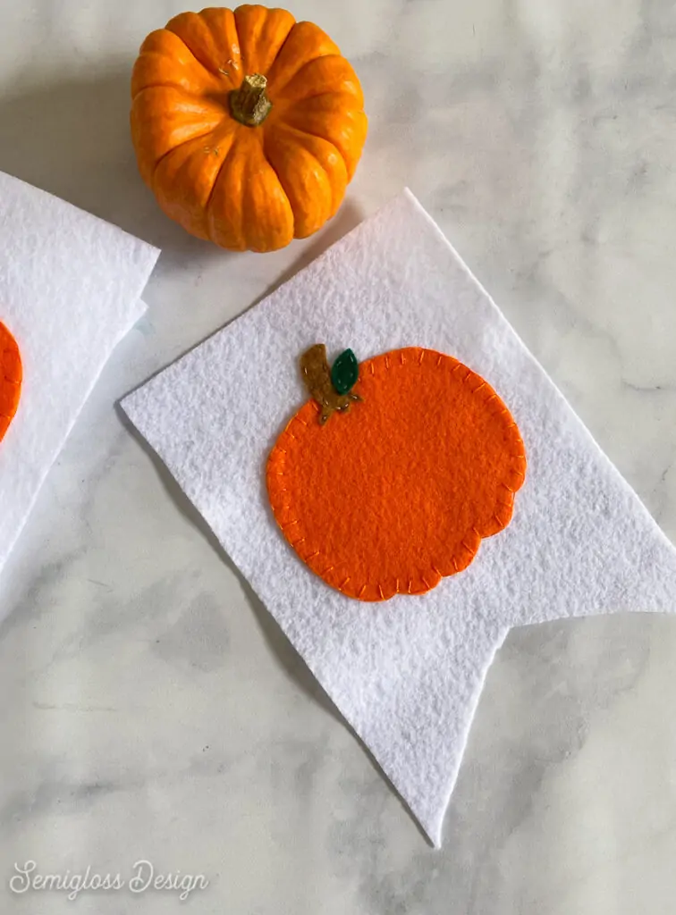 pumpkin sewn onto white felt flag