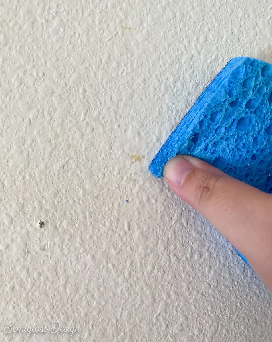 using sponge to clean wallpaper residue from walls