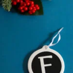 F monogram ornament on teal background