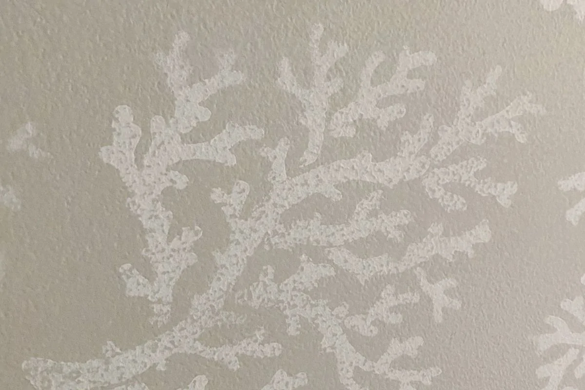 sanded stencil of coral on light gray wall