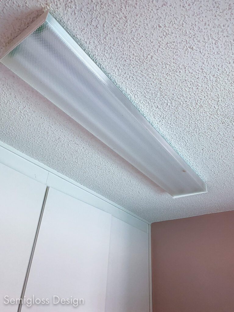 room with popcorn ceiling and fluorescent light