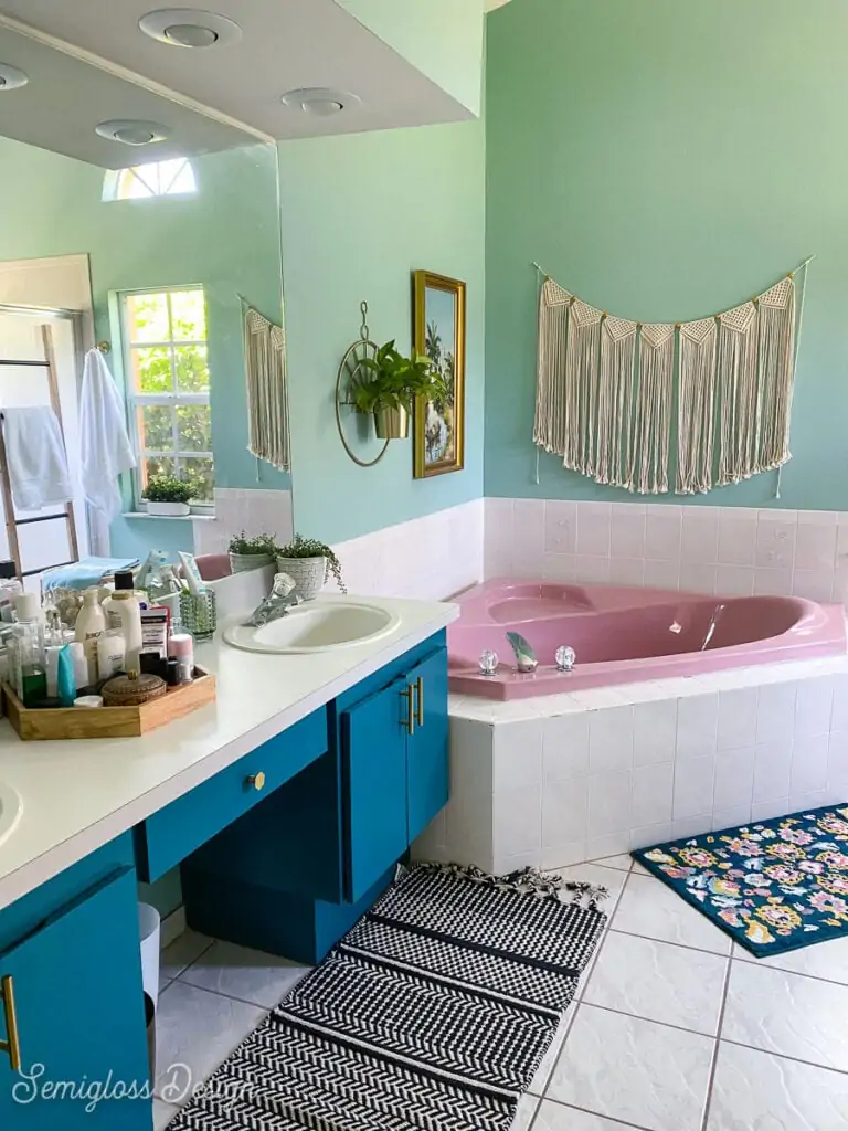 primary bathroom with aqua walls and pink corner tub