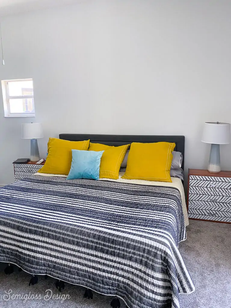 bedroom with black and white bedding and yellow pillows