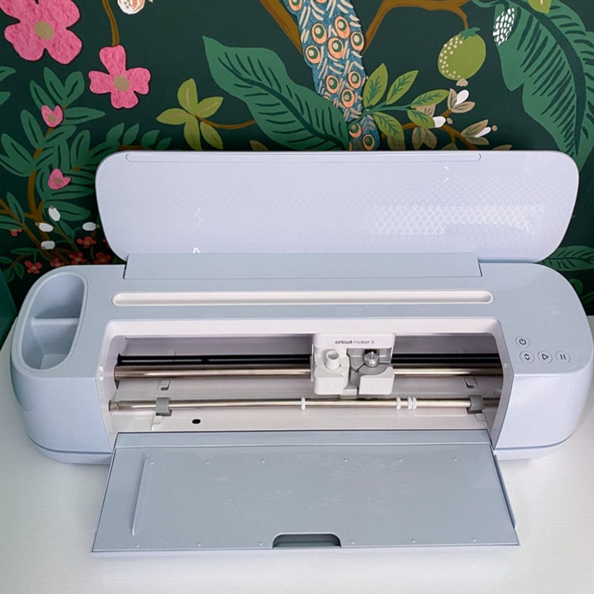 cricut maker in front of green floral wallpaper