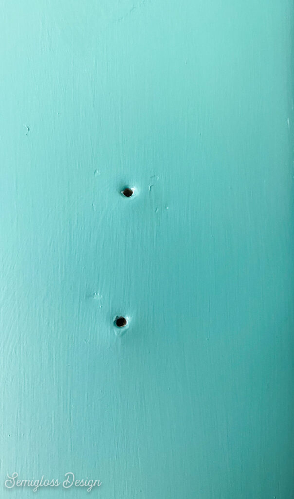 holes on green metal door