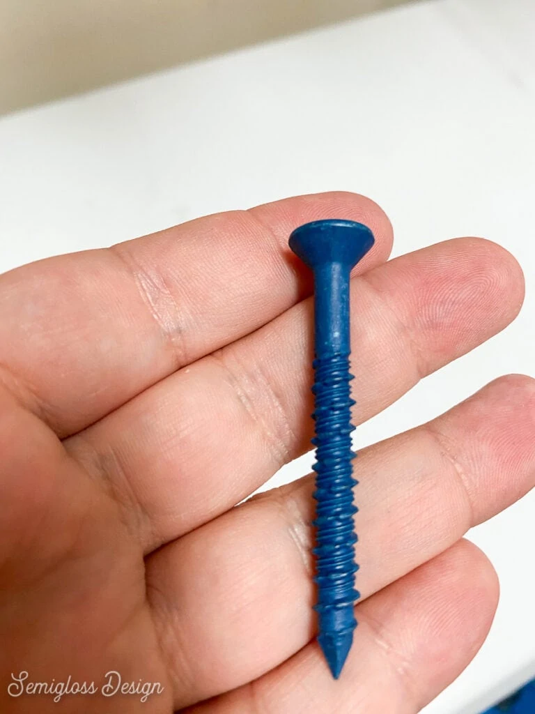 hand holding blue screw