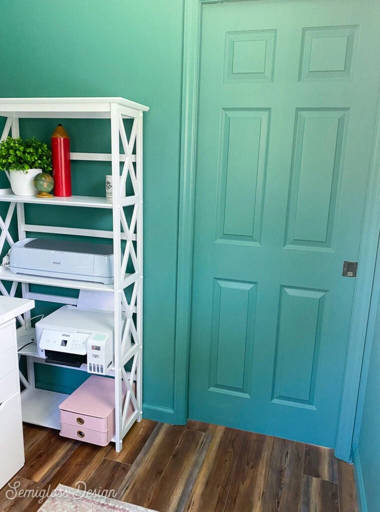 green pocket door and white bookshelf