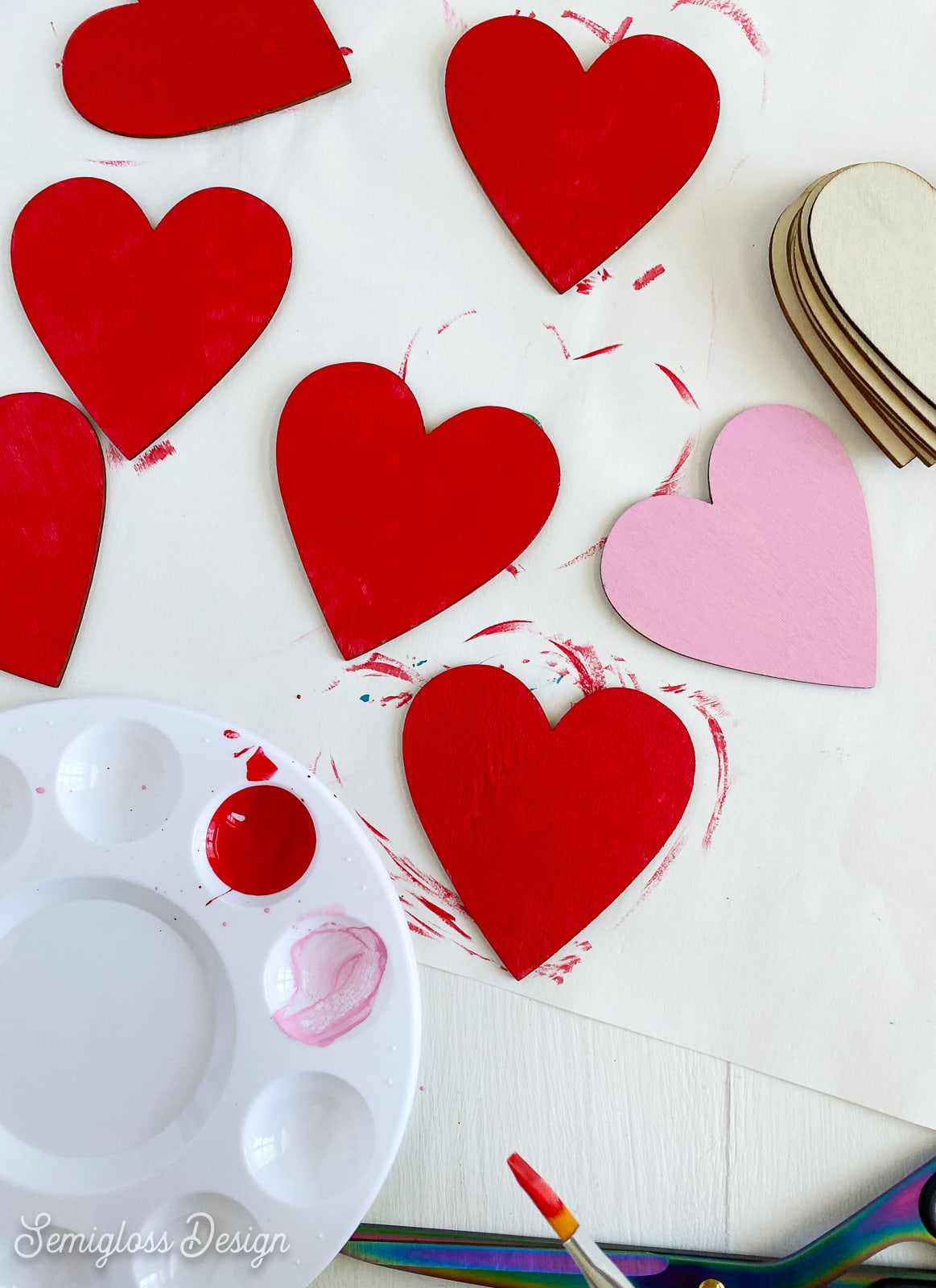 painting wooden hearts red, pink, and white
