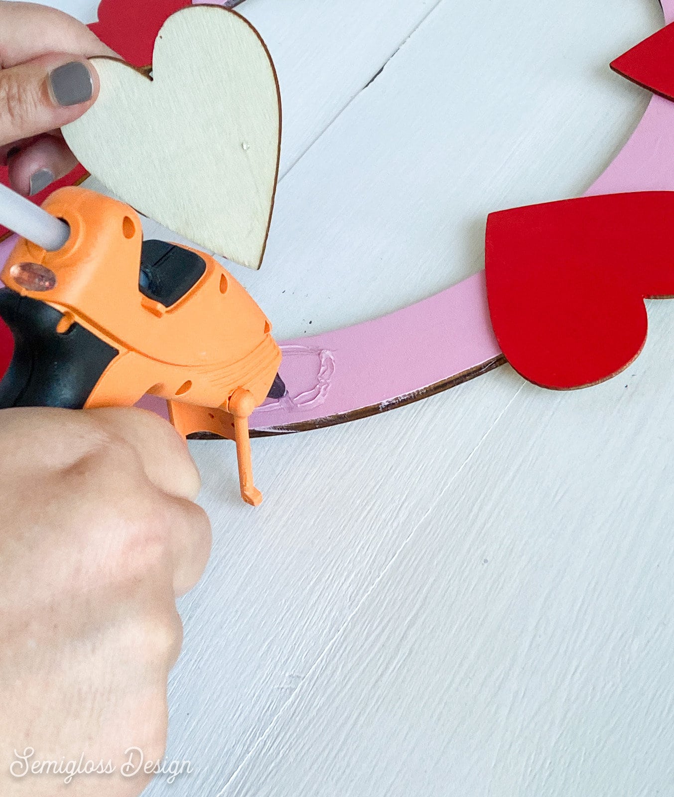 gluing painted hearts to wreath base