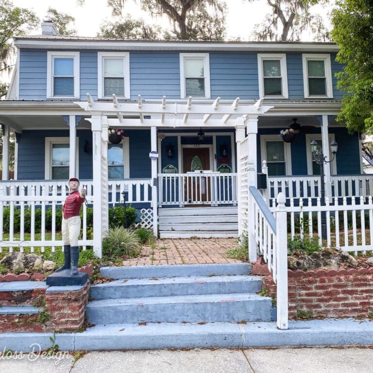 blue house with white fence