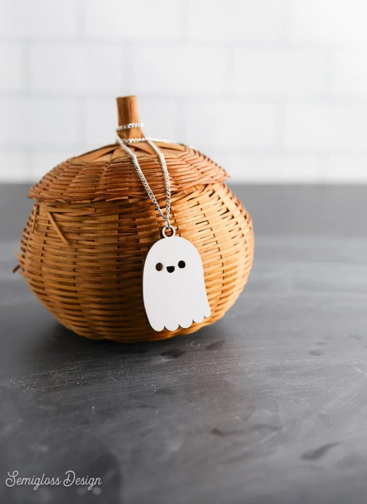 laser cut wood ghost necklace on wicker pumpkin