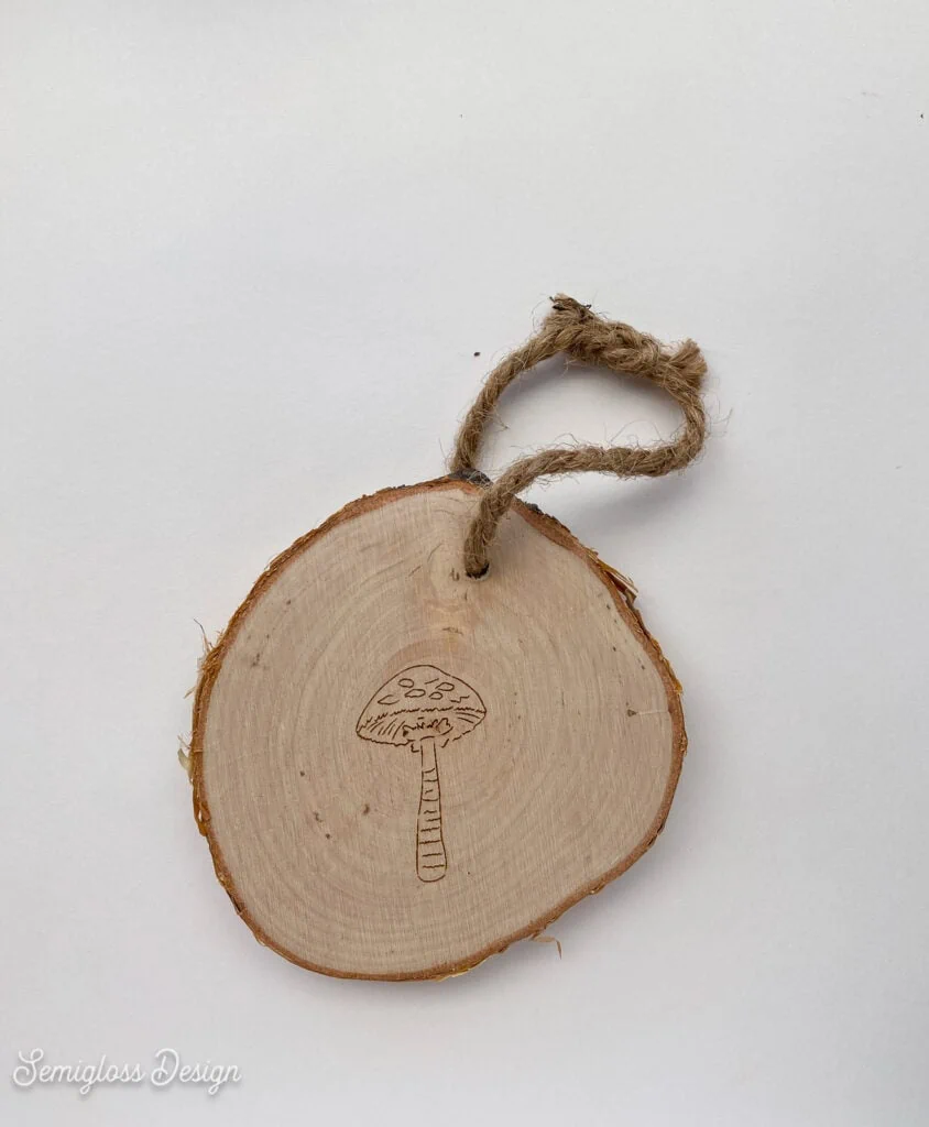 wood slice ornament with mushroom engraved in it