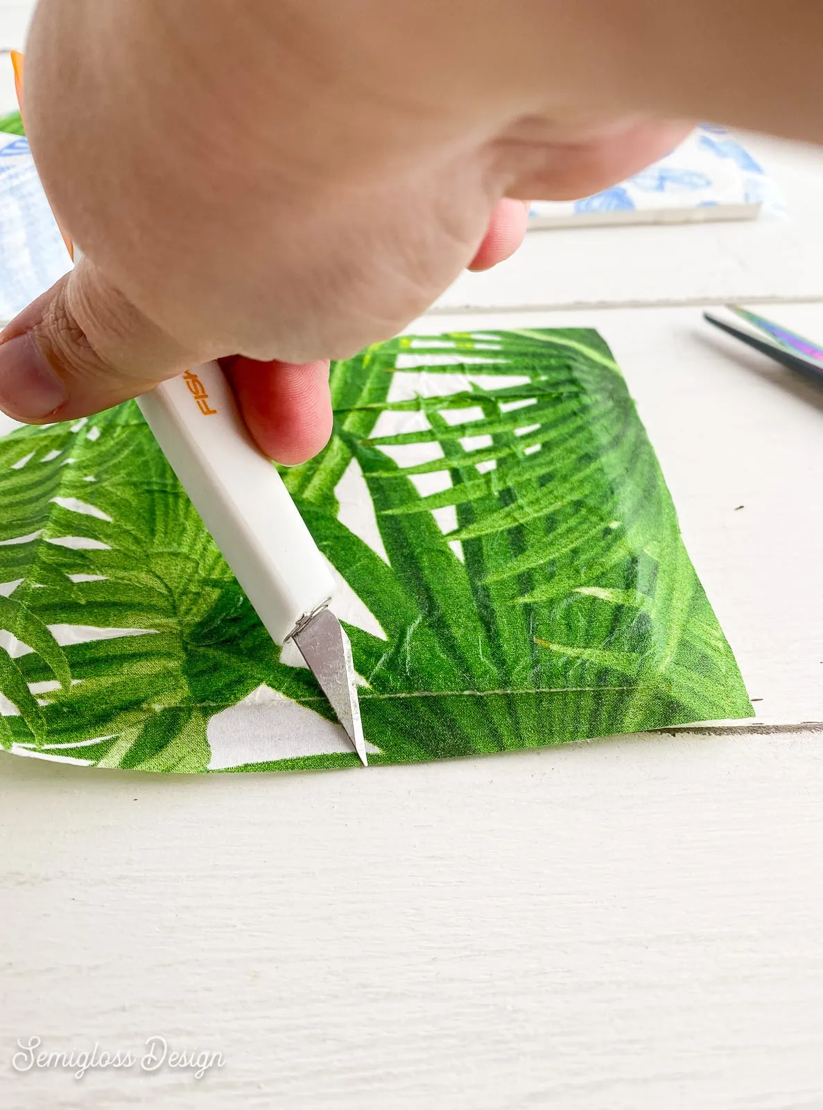 rubbing edge of tile with sharp utility knife
