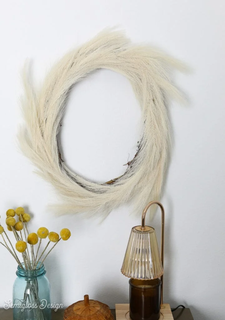 pampas grass wreath, dried billy button florals, and candle lamp