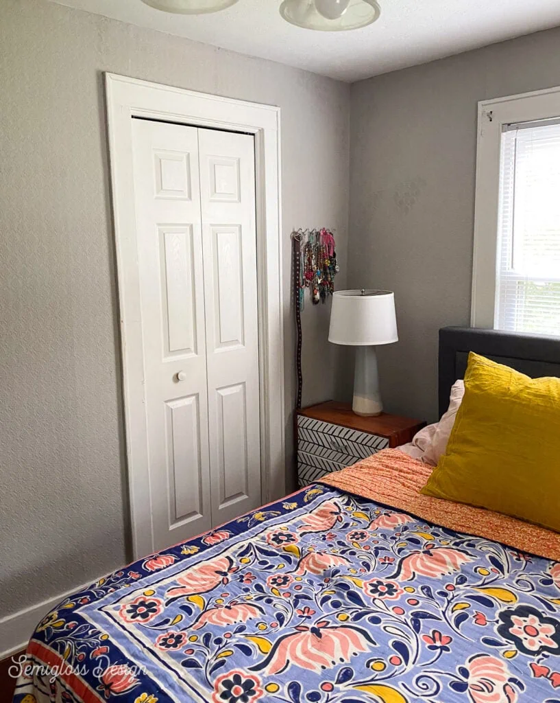 bedroom with gray walls and colorful quilt