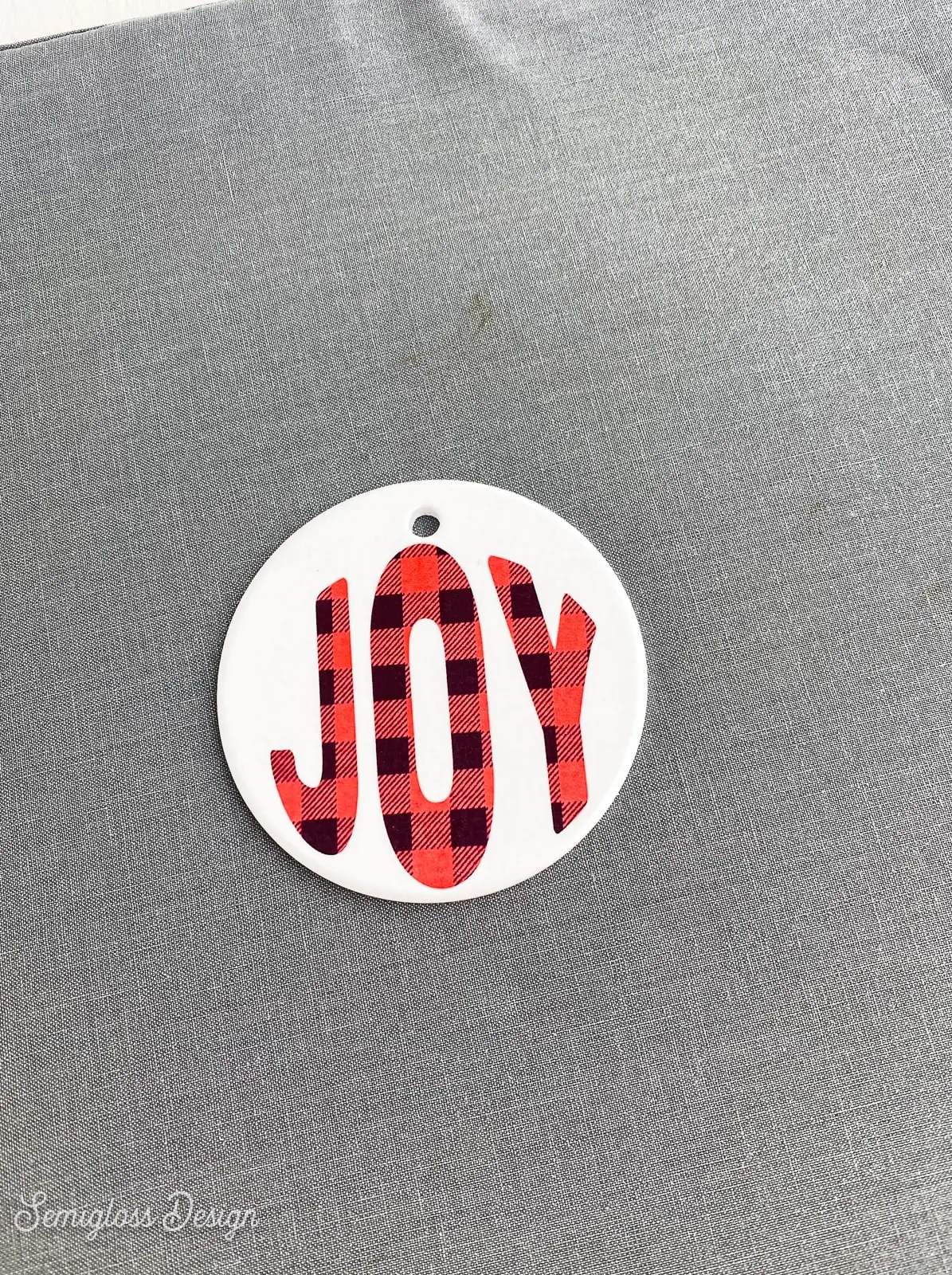 ornament that says "joy" with buffalo check infusible ink