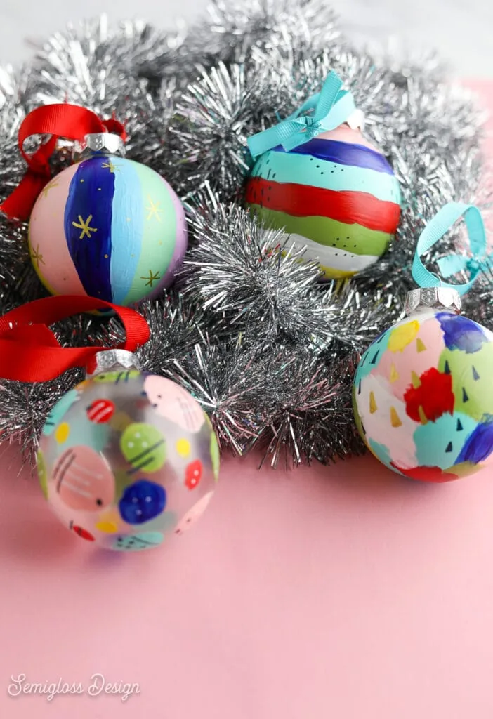 painted ornaments in a pile of silver tinsel