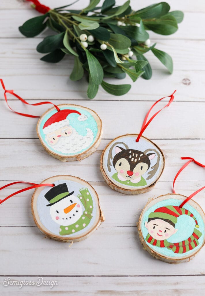 hand-painted Christmas ornaments on wood log slices