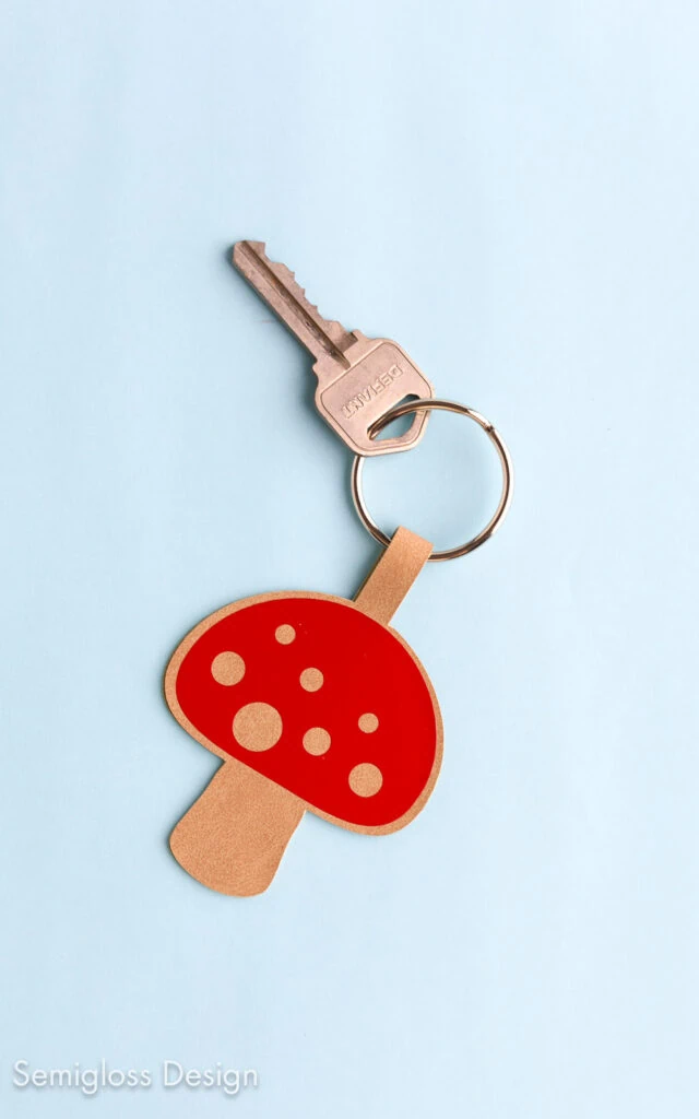 faux leather mushroom keychain on light blue background