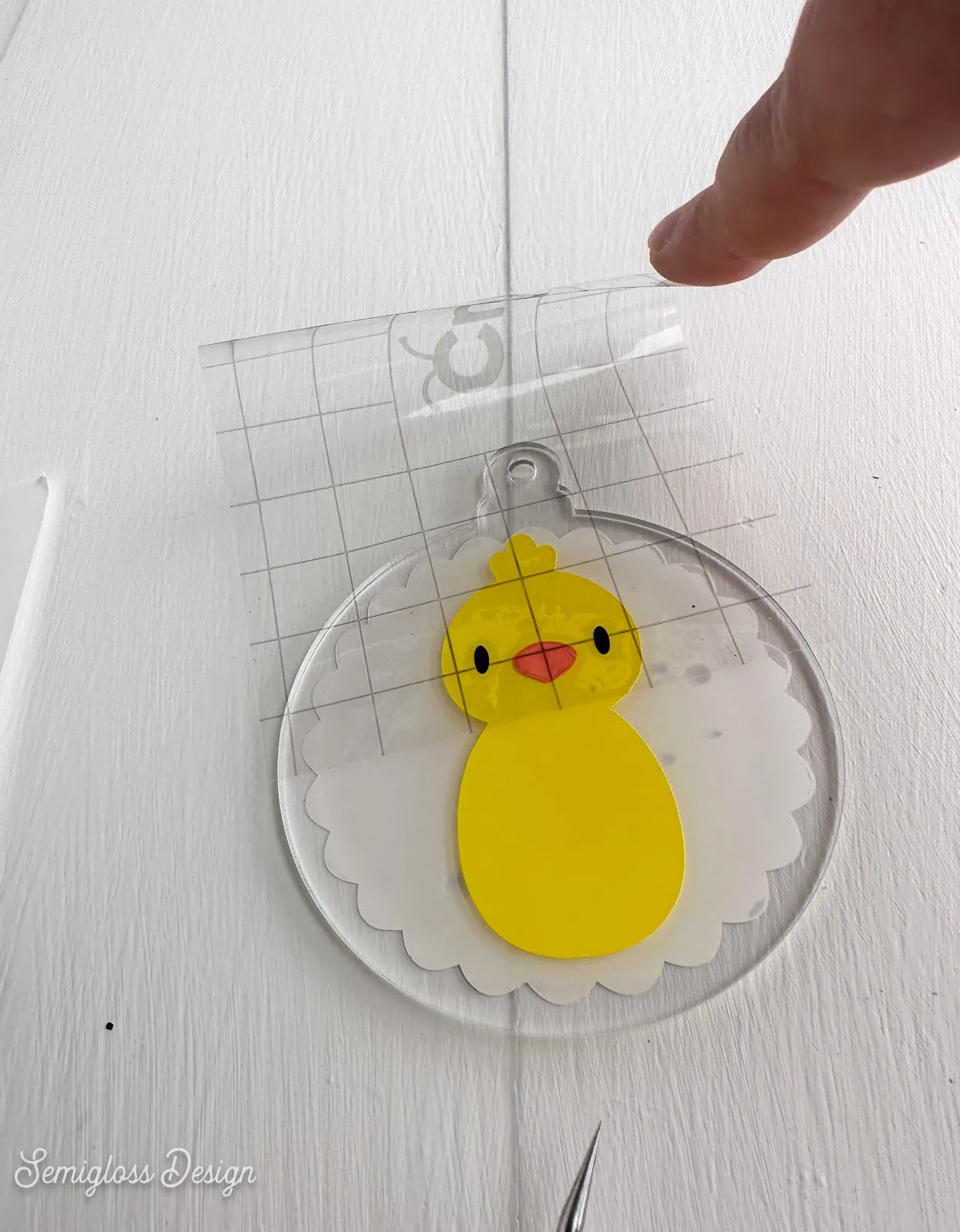 applying vinyl face to chick ornament