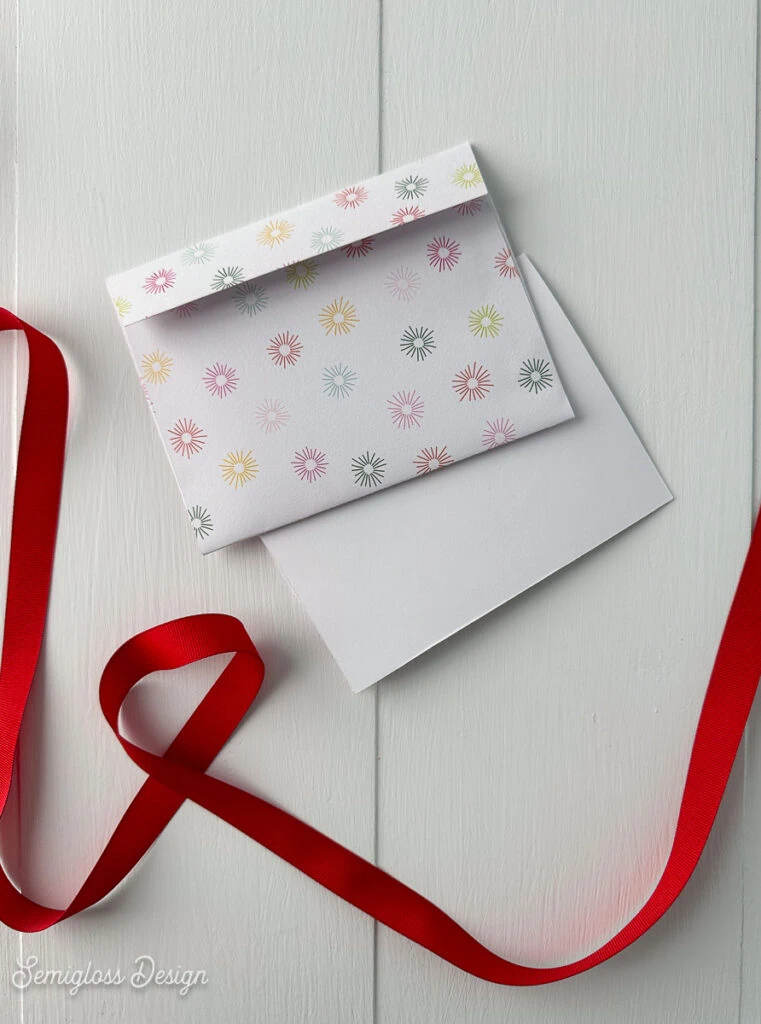 envelope and card with red ribbon