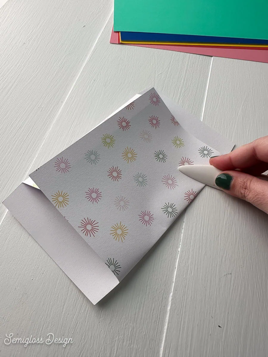 using bone folder to fold envelope 