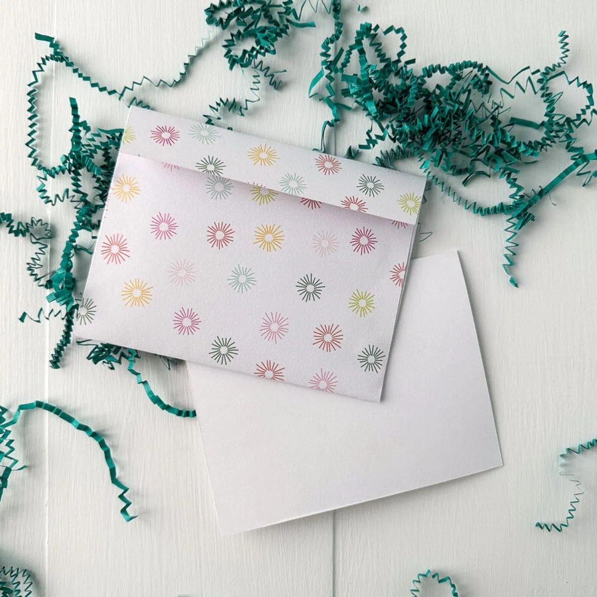envelope with starburst paper with confetti in background