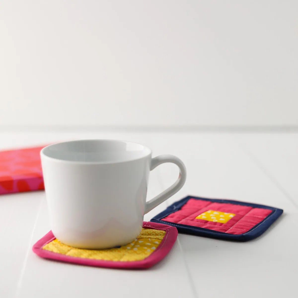 white coffee cup sitting on patchwork coasters