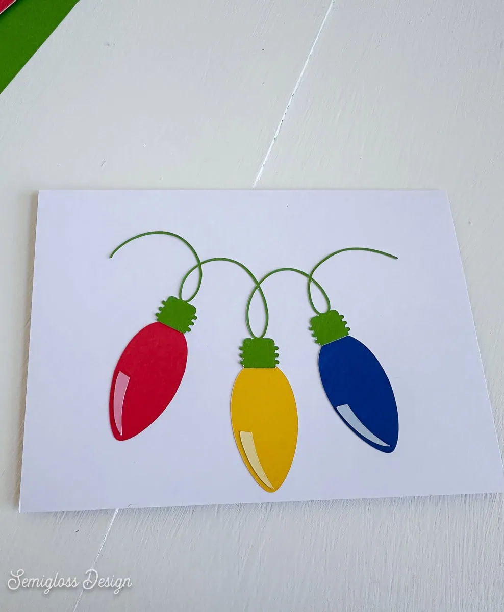 applying paper Christmas bulbs to card