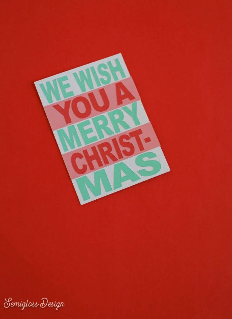 card with colorful paper cut out that says we wish you a merry christmas