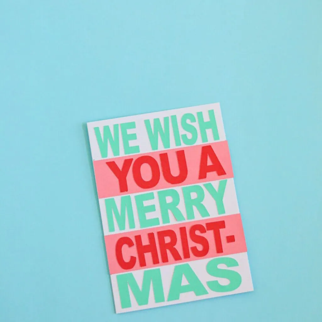 card with cut out paper that says "we wish you a merry christmas"
