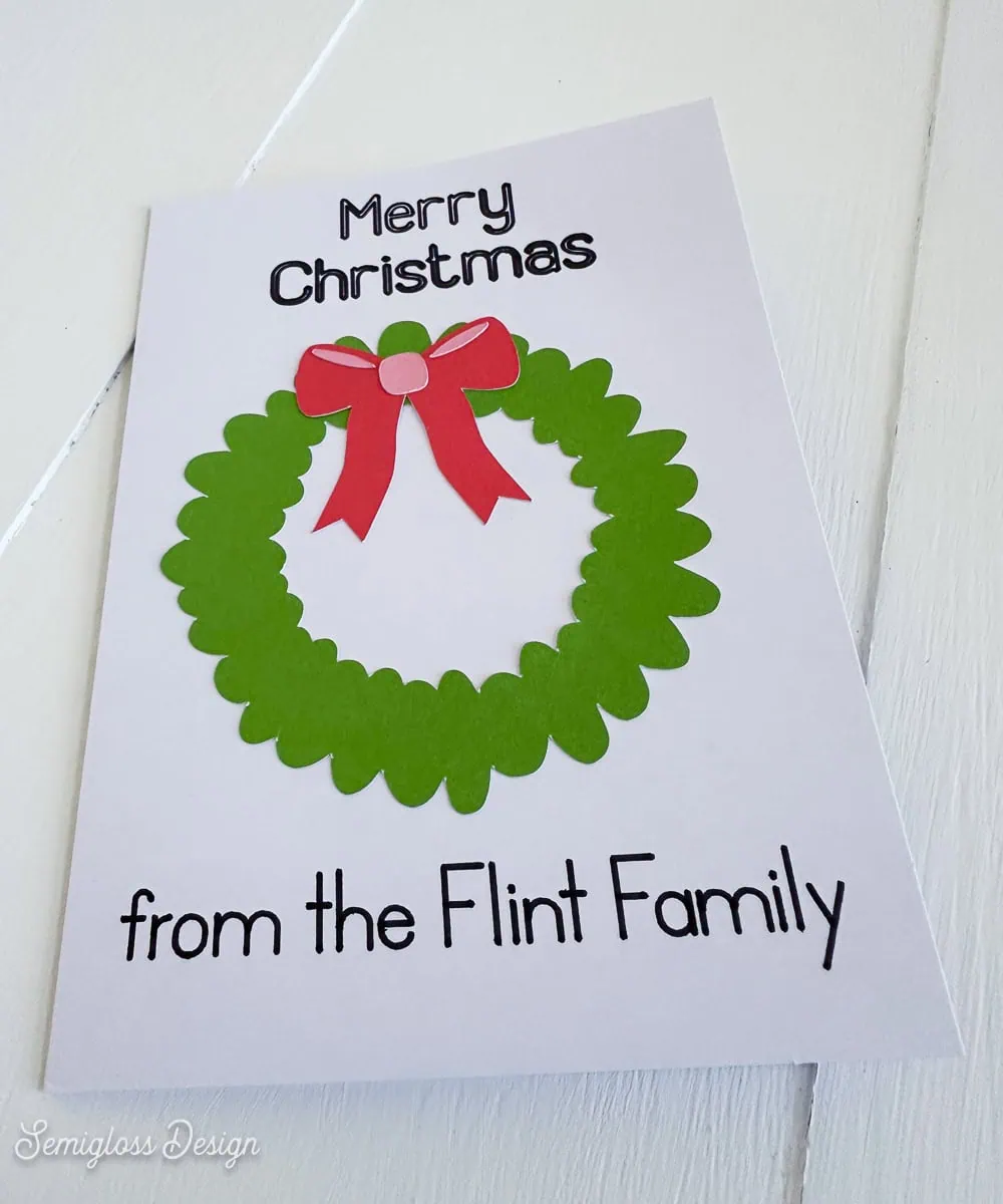 adding bow to wreath on Christmas card