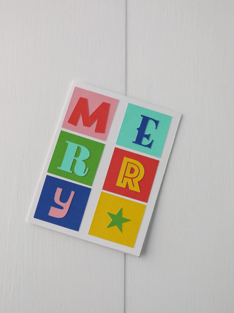 card that says merry using different fonts and colored squares