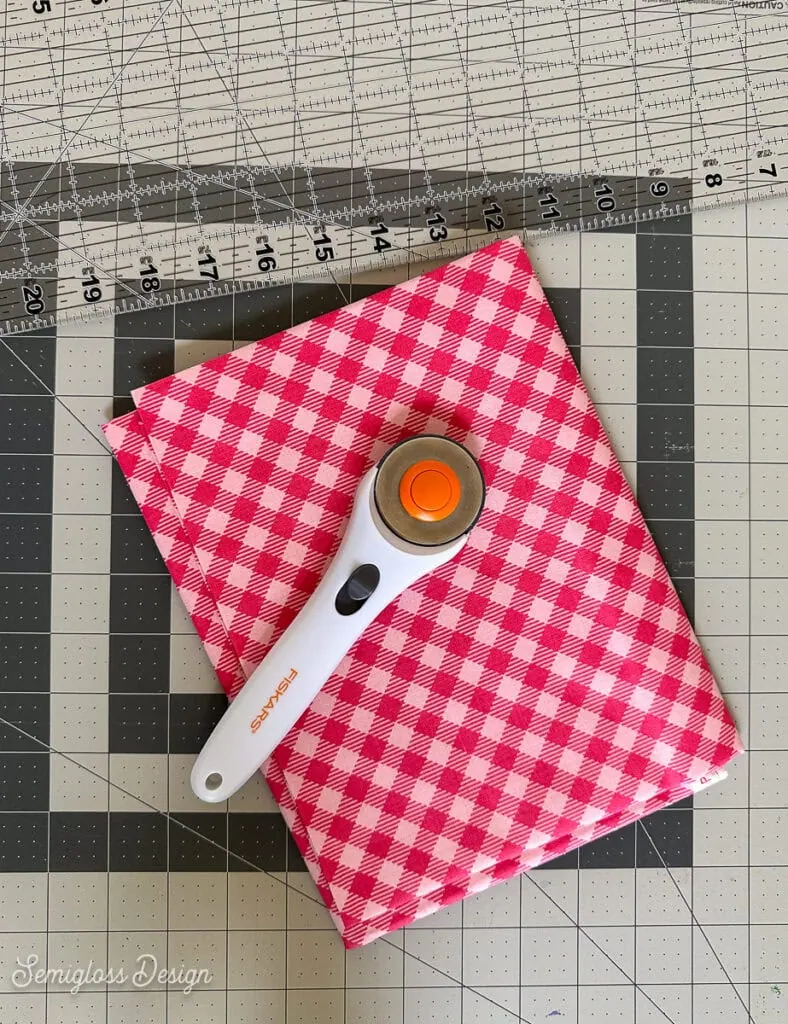 pink gingham fabric, rotary cutter and ruler
